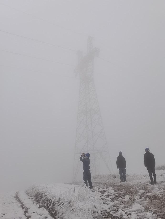 采用“機巡+人巡”的方式全方面巡視線路。圖為1月25日，南方電網(wǎng)云南曲靖供電局輸電管理所工作人員開展35千伏橫阿文線N22塔覆冰觀測工作，該線路剛于去年12月投產(chǎn)。為盡快掌握線路覆冰情況，運維人員冒雪前往，現(xiàn)場氣溫在-2℃左右。 （孔德章）.jpg