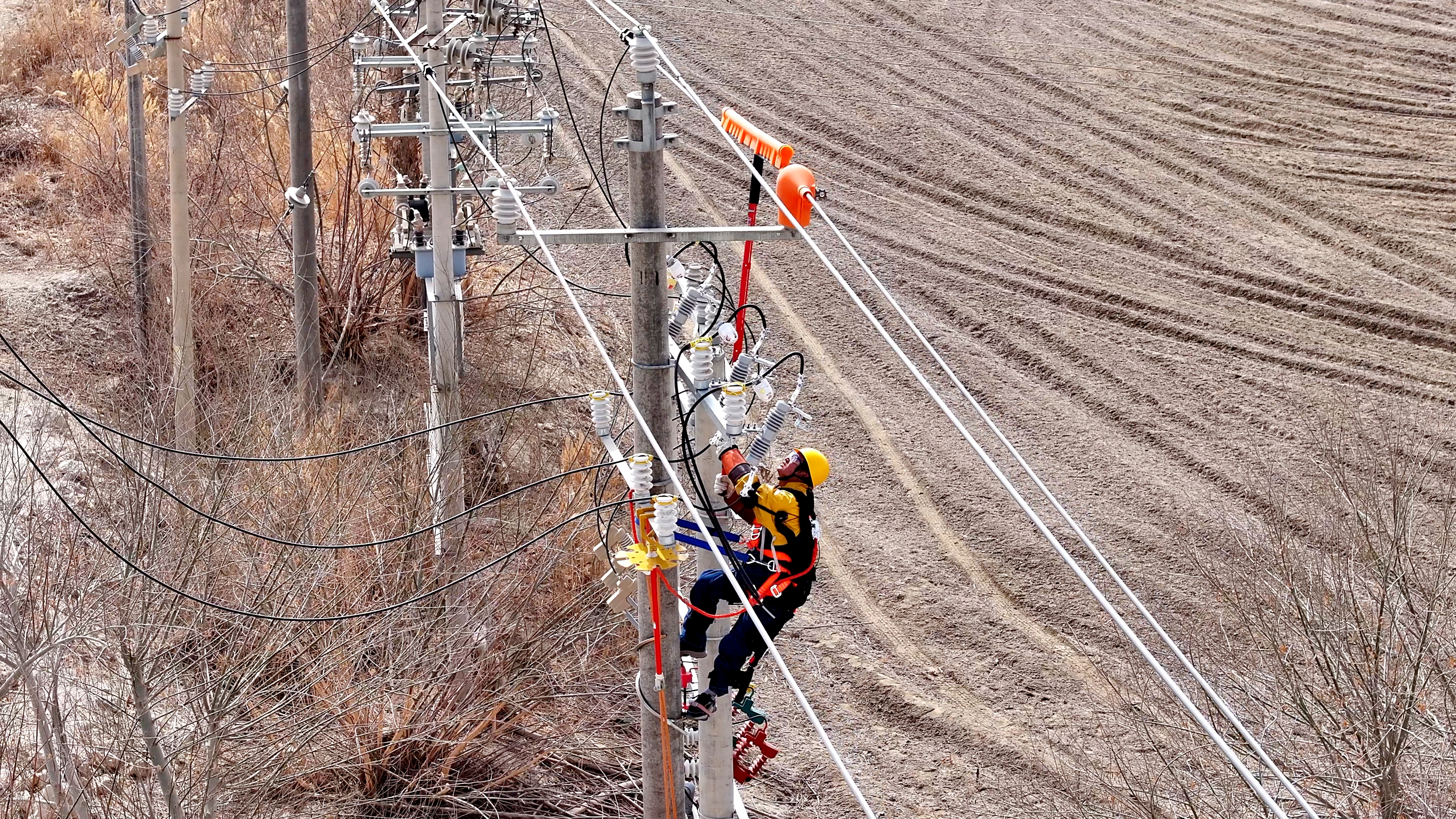 工作人員運(yùn)用人體外骨骼裝備在桿塔上開展帶電作業(yè)。仲澤<span id=