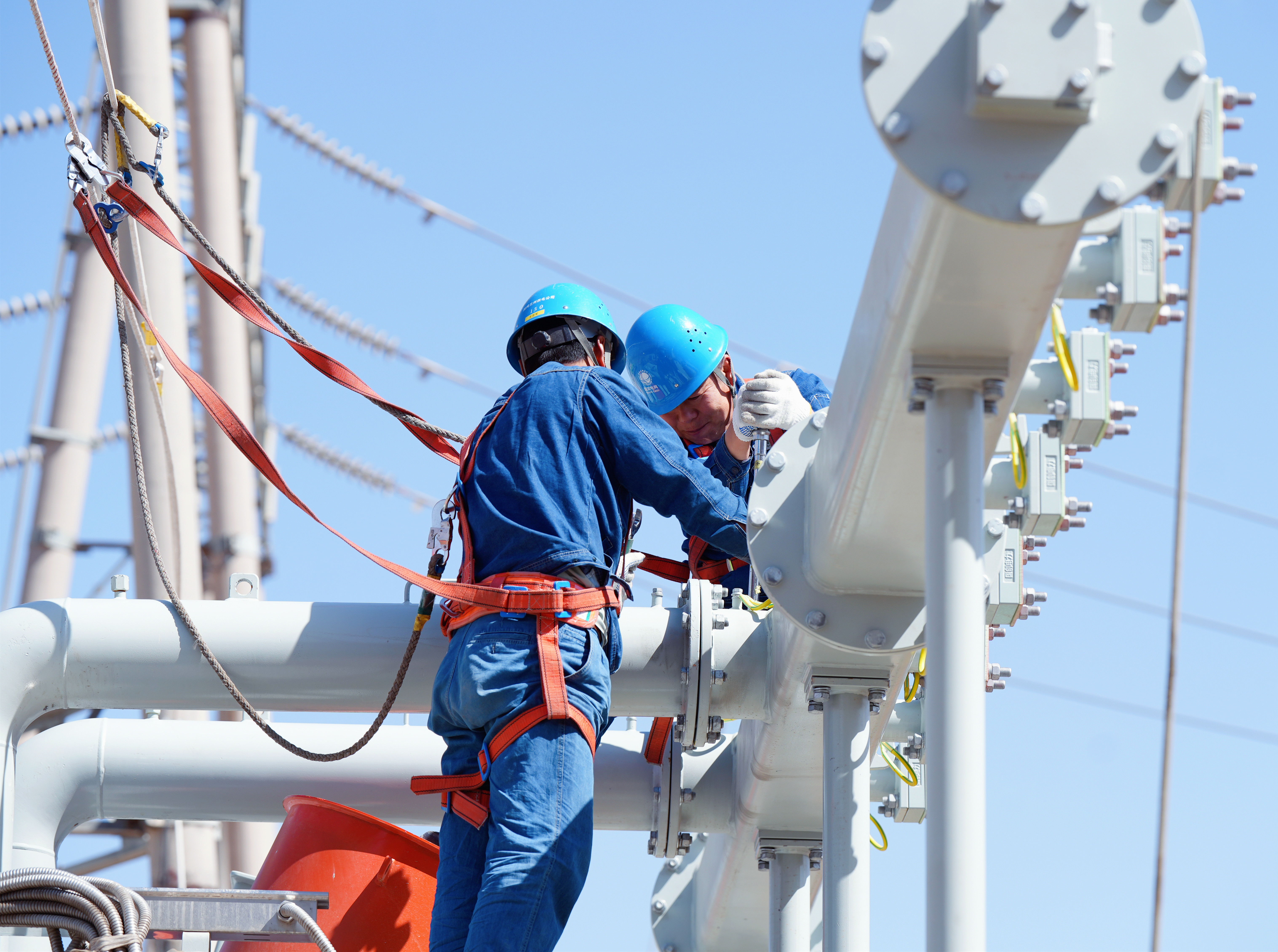 20250509國(guó)網(wǎng)蘭州供電公司變電檢修中心員工在330千伏永登變電站1號(hào)主變安裝散熱器主油管。史雙絢攝  (2).JPG